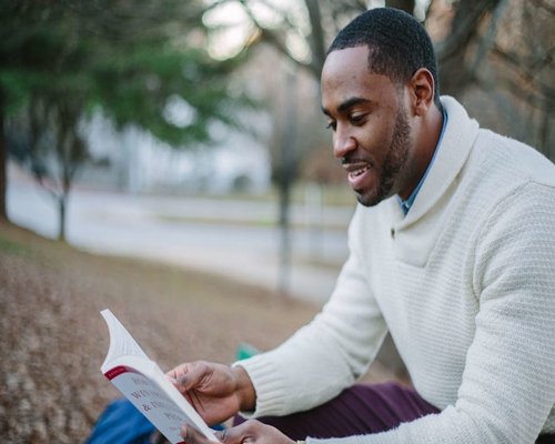 Woman sitting on a bench in autumn reading a book calmly