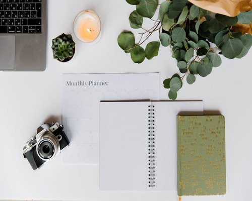Home office desk with plants and notebook for journaling