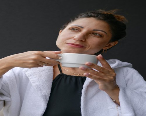 Person holding a warm cup of tea and relaxing